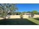 Spacious backyard featuring a white fence, green grass, and mature trees at 4357 Babbling Brook Way, Kissimmee, FL 34746