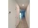A bright hallway with a neutral color palette, tile flooring, and access to various rooms at 4357 Babbling Brook Way, Kissimmee, FL 34746