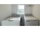 Modern laundry area featuring a GE washer and dryer, set against a bright white wall at 4357 Babbling Brook Way, Kissimmee, FL 34746