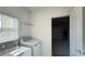 Bright laundry room with new white washer and dryer and a wire shelf for added storage at 4357 Babbling Brook Way, Kissimmee, FL 34746