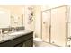 Well-lit bathroom with granite counters, dark cabinets, and a glass-enclosed shower at 4888 Romeo Cir, Kissimmee, FL 34746