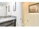 Half bath features a modern vanity with a gray granite countertop and decorative wall art at 4888 Romeo Cir, Kissimmee, FL 34746
