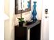 Entryway showcasing a dark console table with decorative vase and mirror by a white front door at 4888 Romeo Cir, Kissimmee, FL 34746