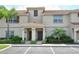 Charming townhouse with a red tile roof, neutral exterior, and well-maintained landscaping at 4888 Romeo Cir, Kissimmee, FL 34746
