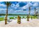 Scenic lakeside lounge with Adirondack chairs offers relaxing views of the water and palm trees at 4888 Romeo Cir, Kissimmee, FL 34746