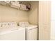 Bright laundry room area with a side-by-side washer and dryer and storage shelves at 4888 Romeo Cir, Kissimmee, FL 34746