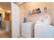 Functional laundry room with washer, dryer, and storage for linens and cleaning supplies at 5101 Staniard Dr, Kissimmee, FL 34746