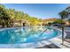 Community pool with clear blue water surrounded by tropical landscaping at 5101 Staniard Dr, Kissimmee, FL 34746