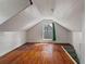 Spacious attic room featuring wood floors, a window, and white painted walls at 514 Massachusetts Ave, St Cloud, FL 34769