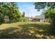 Expansive backyard featuring lush green grass, mature trees, and a charming fire pit for outdoor enjoyment at 514 Massachusetts Ave, St Cloud, FL 34769