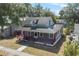 Charming two-story home with inviting red porch, showcasing curb appeal and architectural details at 514 Massachusetts Ave, St Cloud, FL 34769