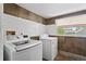 Laundry room featuring tile walls and floor along with modern washer and dryer at 514 Massachusetts Ave, St Cloud, FL 34769