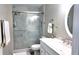 Bathroom featuring marble-style tile in shower with seamless glass doors and oval mirror at 5560 Metrowest Nw Blvd # 106, Orlando, FL 32811