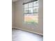 Bedroom featuring neutral paint, wood-look flooring, and a bright window overlooking the green space at 5560 Metrowest Nw Blvd # 106, Orlando, FL 32811