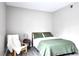 Neutral bedroom with green quilted bedding and a white throw blanket on a nearby chair at 5560 Metrowest Nw Blvd # 106, Orlando, FL 32811