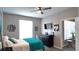 Bright bedroom with a ceiling fan, TV, and a view into the adjacent living room at 5560 Metrowest Nw Blvd # 106, Orlando, FL 32811