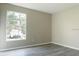 Bedroom featuring neutral paint, wood-look flooring, and a bright window overlooking the street at 5560 Metrowest Nw Blvd # 106, Orlando, FL 32811