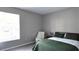Bedroom featuring a green quilted bed set and a nearby window with light streaming in at 5560 Metrowest Nw Blvd # 106, Orlando, FL 32811