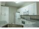 Well-lit kitchen featuring white cabinets, granite counters, and modern appliances at 5560 Metrowest Nw Blvd # 106, Orlando, FL 32811
