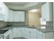 Bright kitchen featuring granite countertops, white cabinetry, and stainless sink at 5560 Metrowest Nw Blvd # 106, Orlando, FL 32811