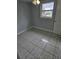 Clean bedroom featuring neutral walls, tile flooring, and a window with natural light at 58 Lincoln St, Frostproof, FL 33843