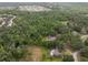 Aerial view of multiple houses in a heavily wooded area with a pond visible at 6340 Nelms E Rd, Lakeland, FL 33811