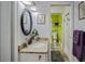 Well-lit bathroom with granite countertop, oval mirror, and convenient access to a toilet room at 6340 Nelms E Rd, Lakeland, FL 33811