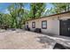 Exterior view of the home with a stamped concrete patio, lush landscaping, and cozy benches at 6340 Nelms E Rd, Lakeland, FL 33811