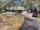 Brick home with mature landscaping, long driveway, detached garage, and a well-maintained exterior at 6340 Nelms E Rd, Lakeland, FL 33811