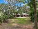 Single-story brick home with a large front yard and mature trees, offering a serene and private setting at 6340 Nelms E Rd, Lakeland, FL 33811
