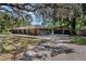 Spacious home featuring a detached garage, long driveway, and lush landscaping, offering ample parking and curb appeal at 6340 Nelms E Rd, Lakeland, FL 33811