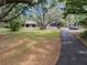 Expansive front yard with mature trees, a long driveway, detached garage, and plenty of room to roam at 6340 Nelms E Rd, Lakeland, FL 33811