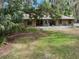 Single-story brick home with a spacious front yard featuring mature trees and beautiful landscaping at 6340 Nelms E Rd, Lakeland, FL 33811
