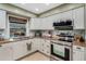 Classic white kitchen featuring stainless steel appliances, granite countertops, and a view of the pool at 6340 Nelms E Rd, Lakeland, FL 33811