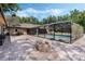 Outdoor patio with a fire pit and a view of the screened-in pool and well-maintained backyard at 6340 Nelms E Rd, Lakeland, FL 33811