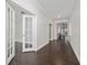 Hallway featuring hardwood floors, white walls, and glass doors leading to the office at 8374 Bowden Way, Windermere, FL 34786