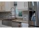 Kitchen detail showcasing the sink, faucet, granite counters, stainless steel appliances and tile backsplash at 8374 Bowden Way, Windermere, FL 34786