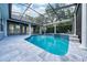 Inviting screened-in pool area with spa, featuring tiled decking and column supports at 8374 Bowden Way, Windermere, FL 34786