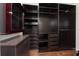 Spacious walk-in closet with custom dark wood shelving and drawers for organized storage at 8374 Bowden Way, Windermere, FL 34786