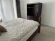 Cozy bedroom featuring a queen bed with a beautiful comforter and a dark wood dresser with storage at 8907 Legacy Ct # 14 205, Kissimmee, FL 34747