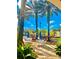 Charming outdoor dining area near pool, surrounded by lush plants and palm trees at 8907 Legacy Ct # 14 205, Kissimmee, FL 34747