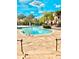 Resort style pool with stone decking, surrounded by lush tropical landscaping, lounge chairs and umbrellas at 8907 Legacy Ct # 14 205, Kissimmee, FL 34747