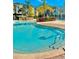 A shimmering blue pool with inviting steps, set amidst lush landscaping and a serene gazebo at 8907 Legacy Ct # 14 205, Kissimmee, FL 34747