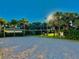 A beautiful outdoor sand volleyball court surrounded by lush tropical trees and green grass under a clear, sunny sky at 8907 Legacy Ct # 14 205, Kissimmee, FL 34747