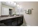 Bathroom featuring dual sinks, granite countertops and silver accents at 9075 Dogleg Dr, Davenport, FL 33896