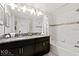 Bathroom featuring dual sinks, granite countertops and a tiled shower and tub at 9075 Dogleg Dr, Davenport, FL 33896