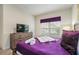 Bright bedroom featuring a cozy bed, dresser, television, and large window with natural light at 9075 Dogleg Dr, Davenport, FL 33896