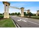 View of the ChampionsGate community entrance, showcasing manicured landscaping and a well-maintained entrance sign at 9075 Dogleg Dr, Davenport, FL 33896