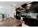 Modern kitchen with dark cabinets, granite countertops, and stainless steel appliances at 9075 Dogleg Dr, Davenport, FL 33896