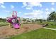 The community playground features a climbing structure with slides and swings for children to play and stay active at 9075 Dogleg Dr, Davenport, FL 33896
